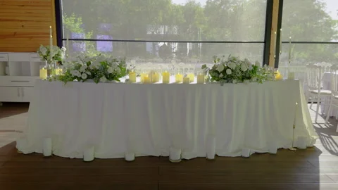A reception table is elegantly set with white linen and white floral decorations Stock Footage 282742834