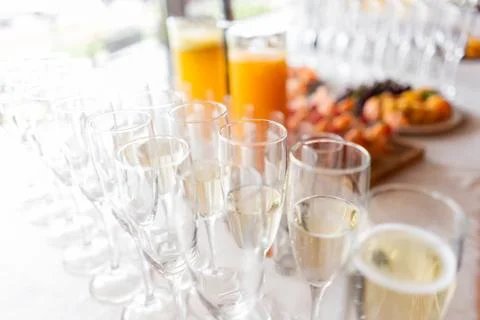 Reception. Table top full of glasses of sparkling white wine with canapes and Foto stock