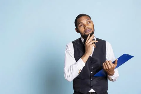 Receptionist bellboy takes notes to offer great concierge services to clients Stock Photos