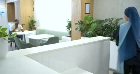 Receptionist at desk helping man checking details on screen, showing tablet Stock Footage 344254017