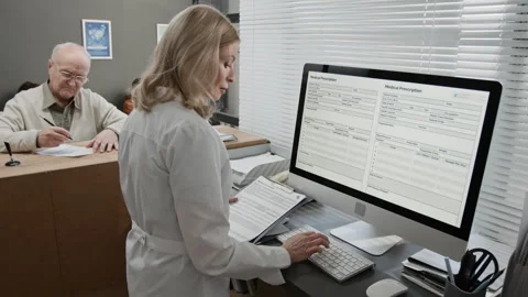 Receptionist Entering Data on Computer at Work in Modern Hospital 스톡 동영상 332673629
