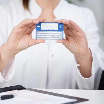 Receptionist showing medical card at counter Stock Photos