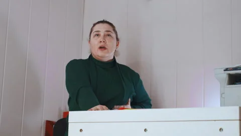 Receptionist shows distress while working at desk. Workplace staff member Stock Footage 345532663