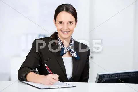 Receptionist signing check on clipboard at reception Stock Photos