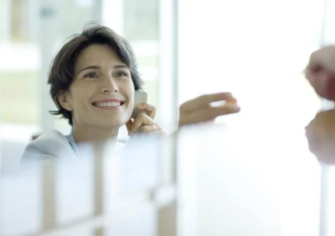 Receptionist smiling, reflection in foreground Stock Photos