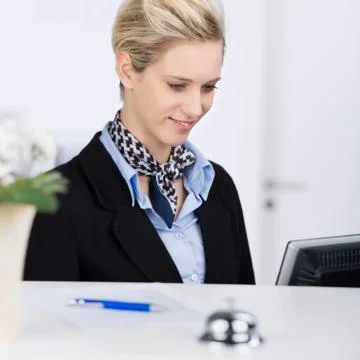 Receptionist using computer at desk 스톡 사진
