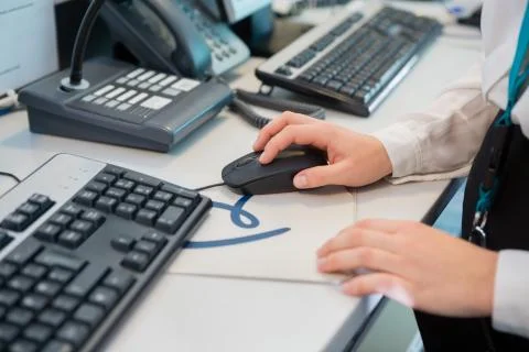 Receptionists Hand Using Computer Mouse At Desk In Airport 写真素材