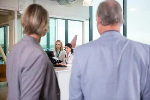Receptionists Using Computer While Senior Business Couple Waitin Foto stock