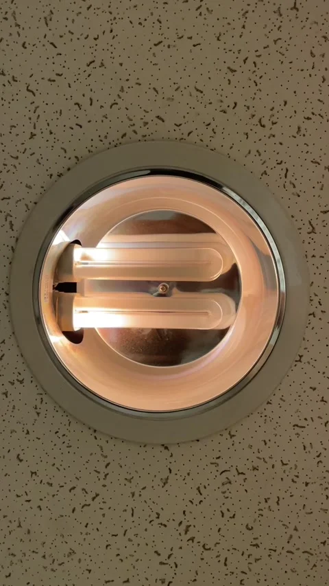 Recessed circular ceiling light with twin u shaped fluorescent tubes glowing Stock Footage 341664014