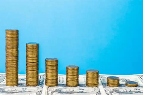 Recession graph. Stack coins on the background of banknotes. Financial crisis Stock Photos