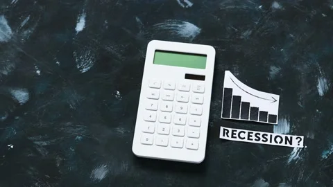 Recession text next to calculator with graphs showing stats going down Stock Footage 196203563