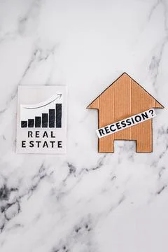 Recession text with question mark over house icon made of cardboard next to r 스톡 사진