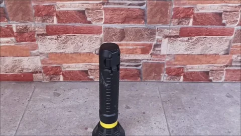 Rechargeable LED Flashlight on Stone Floor with Brick Wall Background Stock Footage 331913721