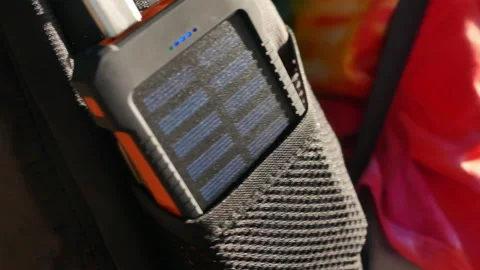 A rechargeable mobile power pack with solar panels in female traveler's backpack Stock Footage 160084605