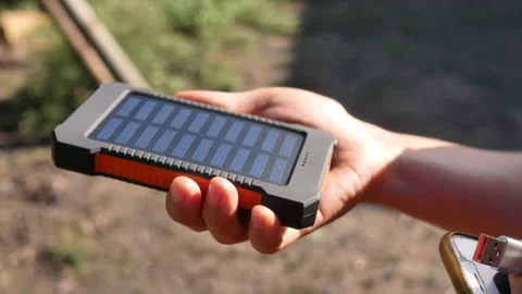 A rechargeable mobile power pack with solar panels in female traveler's hands. Stock Footage 160084884