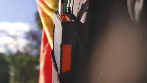 A rechargeable mobile power pack with solar panels in female traveler's backpack Stock Footage 160085037
