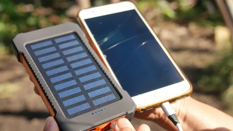 A rechargeable mobile power pack with solar panels in female traveler's hands. Stock Footage 160085119