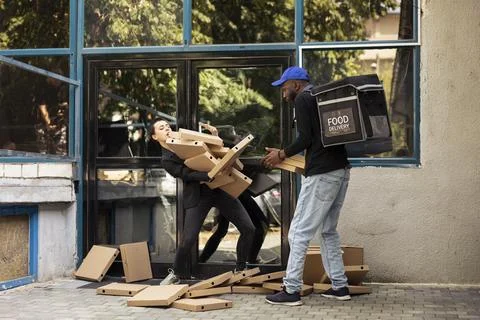Reckless black courier losing control of a huge pizza boxes stack 写真素材