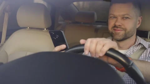 Reckless man driving and using smartphone instead of looking at road Stock Footage 286885535