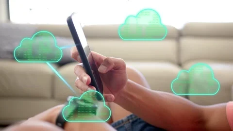 Reclining man tapping phone on sofa, teal cloud appearing and initiating cloud Stock Footage 333553034