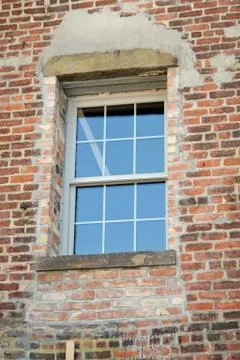 A reconstructed window in a red brick wall Stock Photos