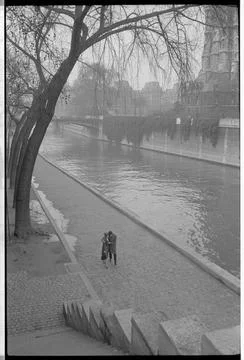 RECORD DATE NOT STATED A couple walking along the Seine River in Paris, To... Stock Photos