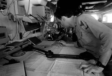 RECORD DATE NOT STATED A crew member plots a bearing on a chart on the bri... Stock Photos