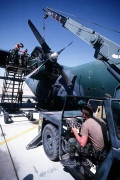 RECORD DATE NOT STATED Ground crew members replace an engine on a C-130 He... Foto stock