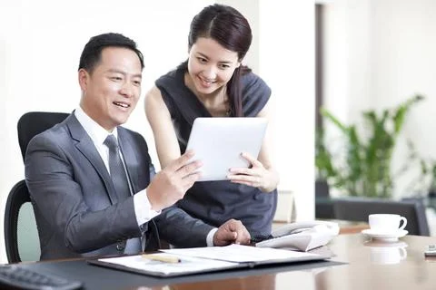 RECORD DATE NOT STATED Happy Chinese business colleagues using digital tab... Stock-Fotos