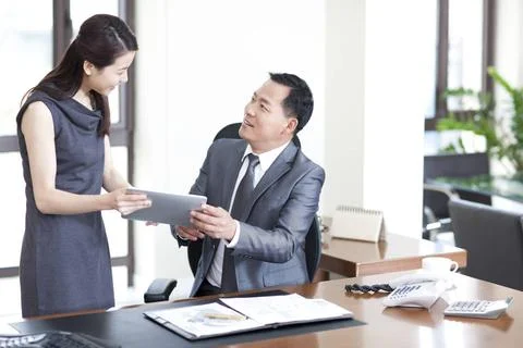 RECORD DATE NOT STATED Happy Chinese business colleagues using digital tab... Stock-Fotos