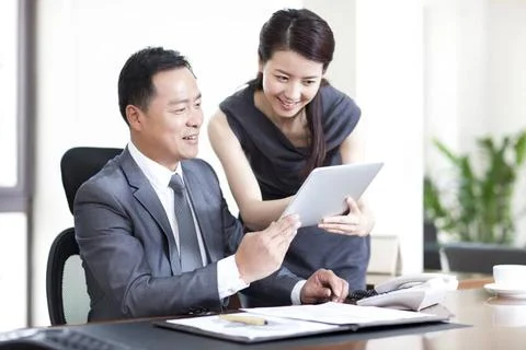 RECORD DATE NOT STATED Happy Chinese business colleagues using digital tab... Stock-Fotos