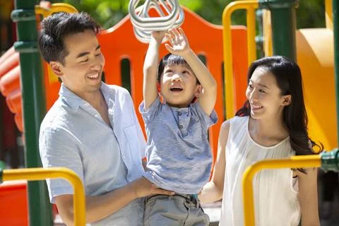 RECORD DATE NOT STATED Happy young Chinese family playing in amusement par... Stock Photos