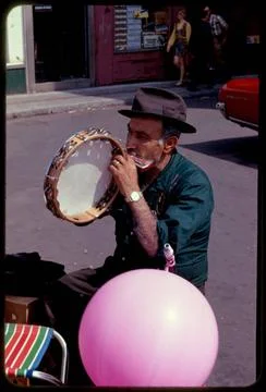 RECORD DATE NOT STATED Man playing tambourine and harmonica , Street music... Stock Photos