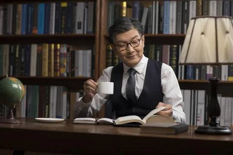 RECORD DATE NOT STATED Senior Chinese businessman reading book in study Be... 스톡 사진