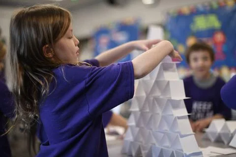 RECORD DATE NOT STATED A student balances folded papers during a learning ... Foto stock