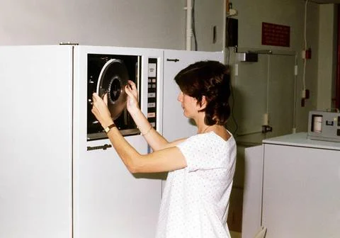 RECORD DATE NOT STATED A technician changes the tape on a data processing ... Stock Photos