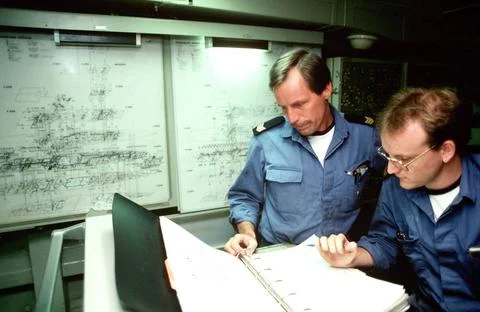 RECORD DATE NOT STATED Two sailors look over a schematic diagram in the te... Stock Photos