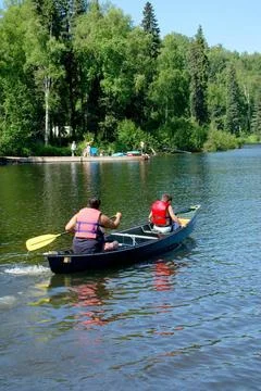 RECORD DATE NOT STATED  Two people in canoe on South Rolly Lake with swimm... Stock Photos
