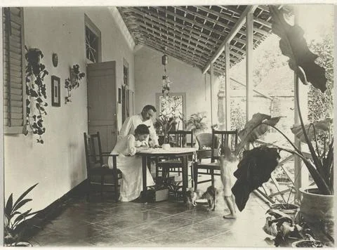 RECORD DATE NOT STATED  Unknown couple writing on a porch in the Dutch Eas... Fotos Stock