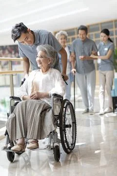 RECORD DATE NOT STATED Young Chinese nurse assistant taking care of senior... Stock Photos