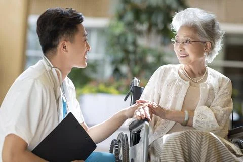 RECORD DATE NOT STATED Young Chinese doctor talking with patient in nursin... Fotos Stock