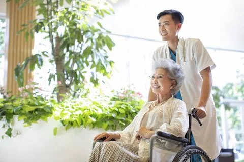 RECORD DATE NOT STATED Young Chinese doctor taking care of senior woman in... 스톡 사진