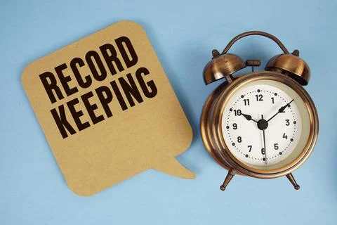 Record Keeping text with alarm clock on blue background Stock Photos