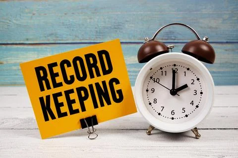 Record keeping text written on paper card with alarm clock on wooden backgrou Stock Photos