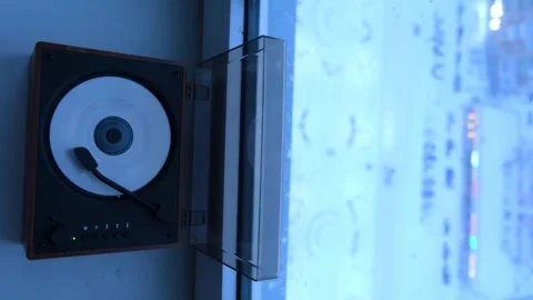 Record player spinning near a window with rain outside. Musical device playing Stock Footage 333581305