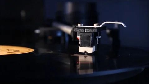 Record player stylus on a rotating disc with orange label HD Video stock 97176535