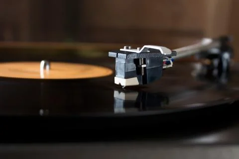 Record player stylus on a rotating disc with orange label 库存照片
