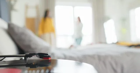 Record player tonearm is remaining still while two friends are entering frame to Stock Footage 344405181
