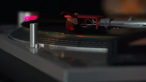 Record playing on a turntable with a chrome arm, red cartridge and lead wires Stock Footage 127322282