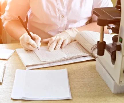 Record the result of a blood test in a log, microscope, hands, gloves, magazine Photos